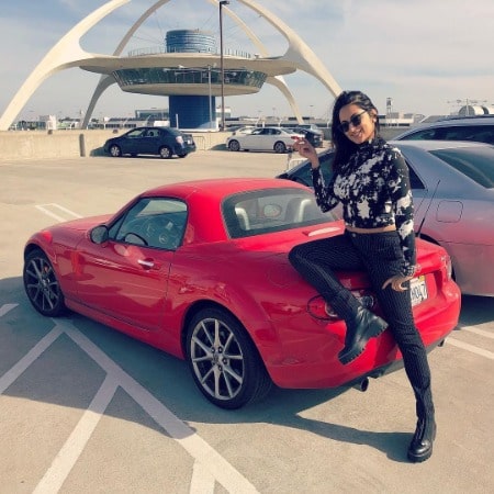 Zehra Fazel is posing behind her new red car.